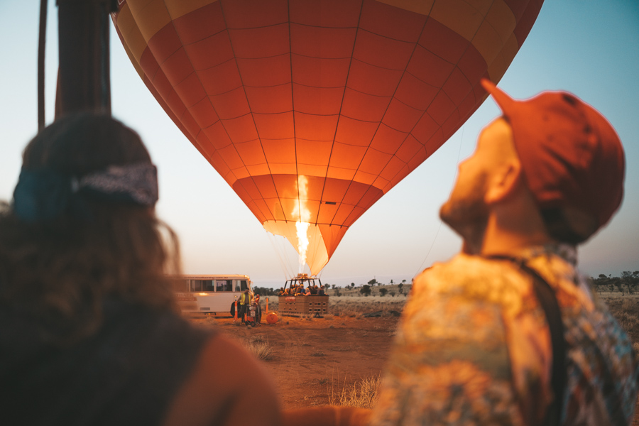 a couple of people watching a hot air balloon.