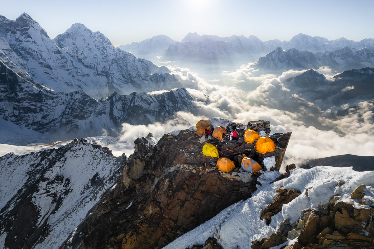 a group of tents sitting on top of a snow covered mountain