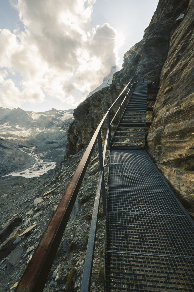 a set of metal stairs going up a mountain.