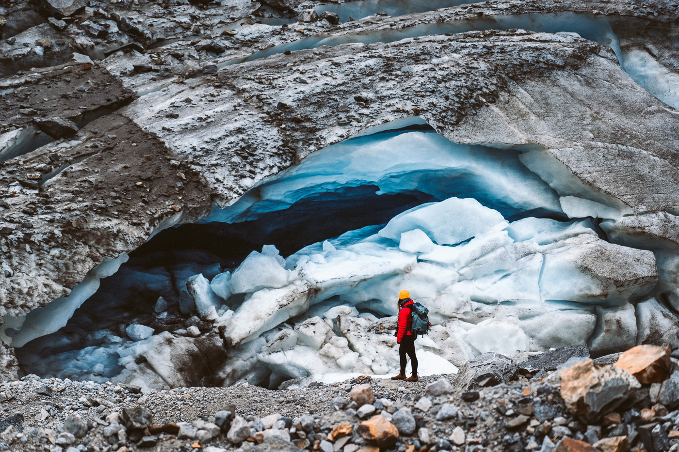 a person standing in front of an ice cave.