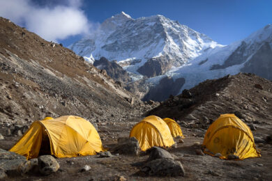 a group of yellow tents sitting on top of a mountain