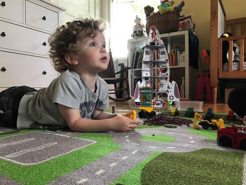 Clark Tinker, age 2 in this photo, looks up from playing with his toy truck to listen to his mother ask him a question.