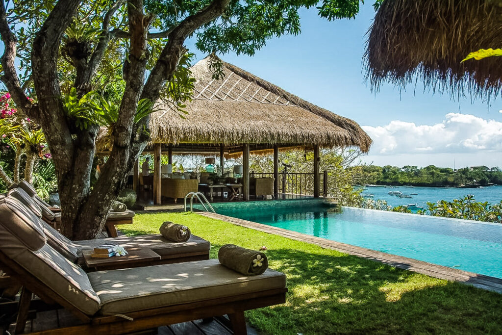a pool with lounge chairs and a thatched roof.