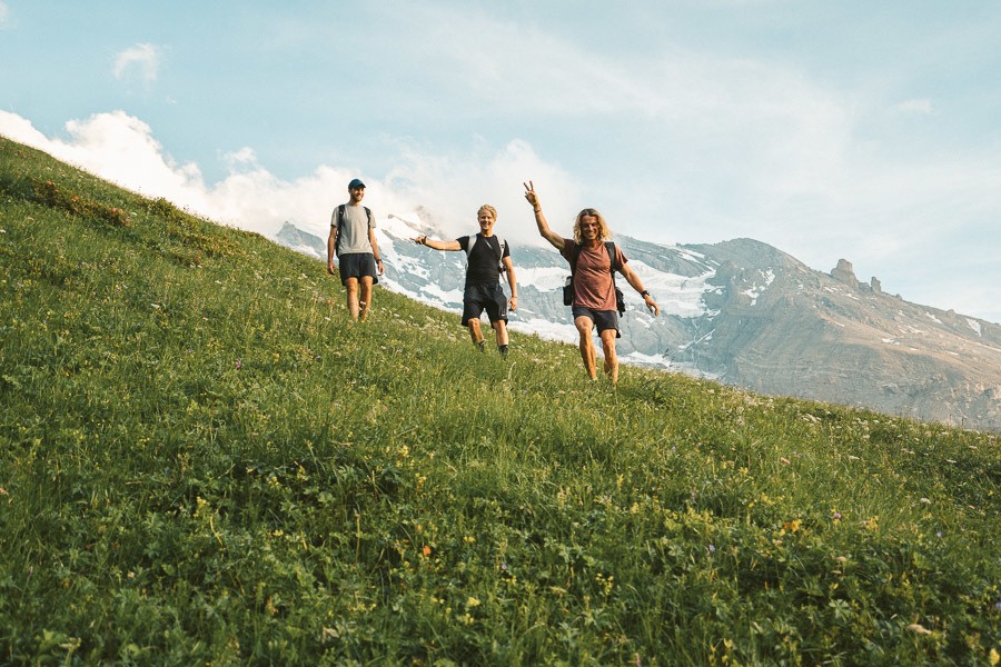 a group of people standing on top of a lush green hillside.
