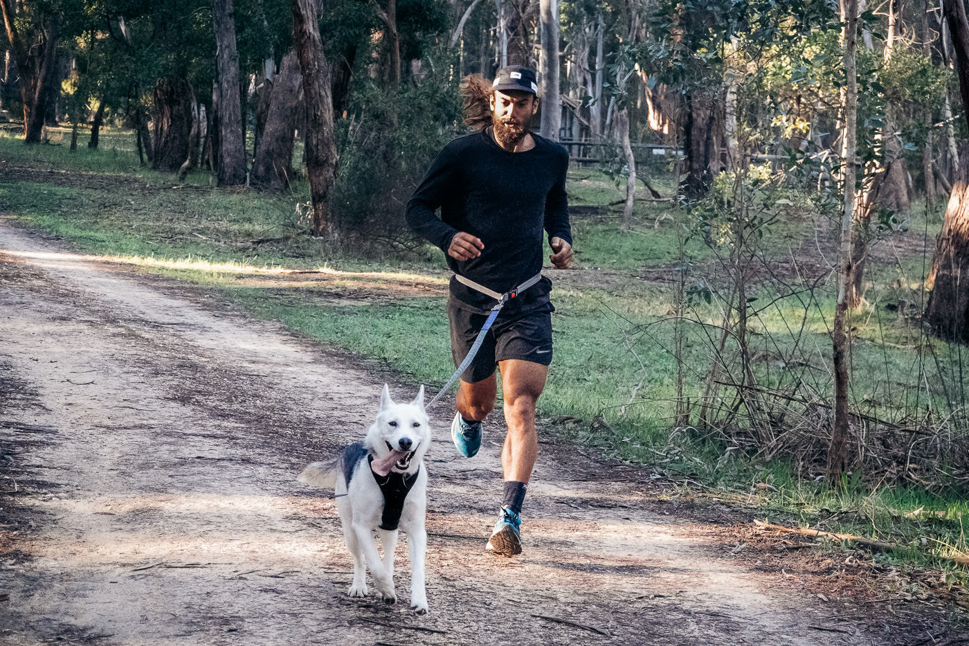 a man running with a dog on a leash.