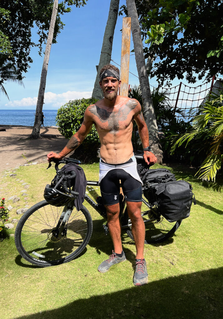 a shirtless man standing next to a bike